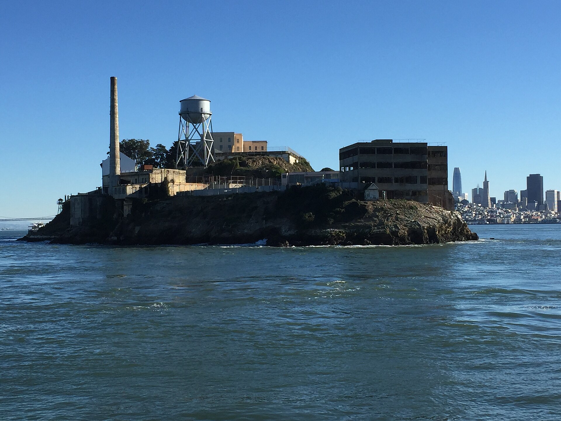 The prison island from the water, city skyline beyond